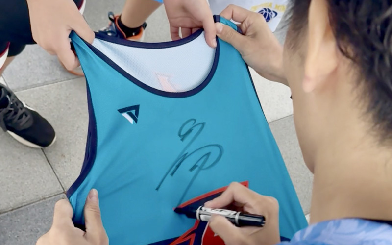 ユニフォームにサインをするYASUOJAPAN代表の飯島康夫